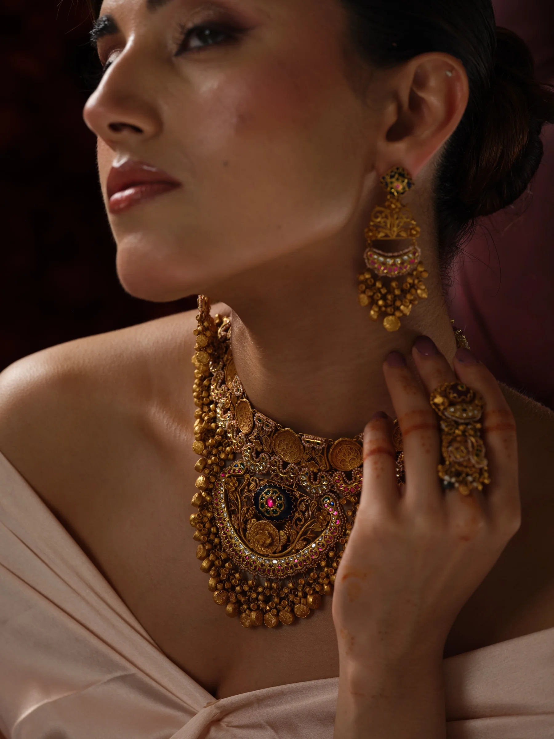 Close-up of a temple gold collar with a deity medallion and a gold cocktail ring
